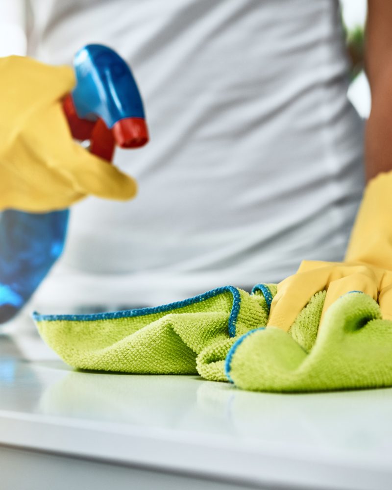 Shot of an unrecognizable woman cleaning a table at home